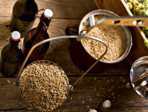 Featured | Top view of a man weighs malt for home brewing of beer | Home Brewing: Fun Hobby Or Vital Skill?