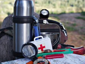 Feature | Survival kit in nature background | Items Preppers Should Keep Around