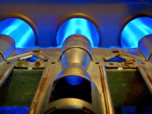 Feature | Closeup of inside a home natural gas furnace showing blue jets of fossil fuel burning | Electrical Backup For A Gas Furnace