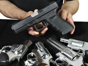 Salesman selling pistols and revolver assorted firearms for sale at gun show | The Gun Show Loophole Explained | Featured