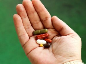Featured | A person hand holding capsule in hand | Best Vitamins For Men & Women And OTC Medicines To Stock Up On