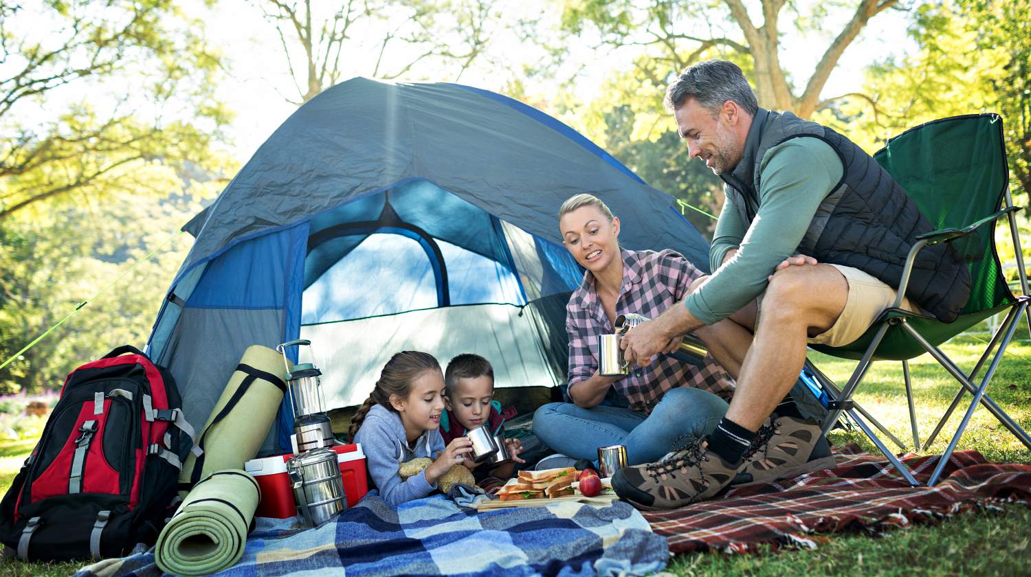 Feature | Family having snacks and coffee outside the tent at campsite | Camping Snacks | Appetizing Recipes Perfect Outdoors