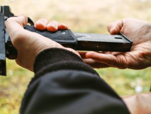 Featured | Man hands holding and loading gun magazine in the pistol at the shooting range | How To Load A Pistol Magazine