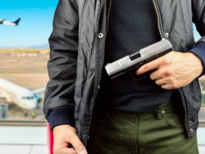 Featured | Closeup of an armed terrorist at the airport | Flying With Firearms | Part Two: During Travel And After Arrival