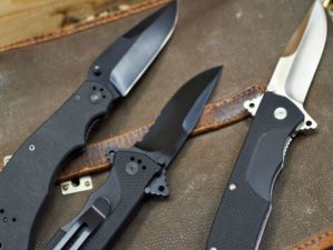 Feature | Three folding knives on top of leather bag | Eye-Catching Folding Hunting Knives
