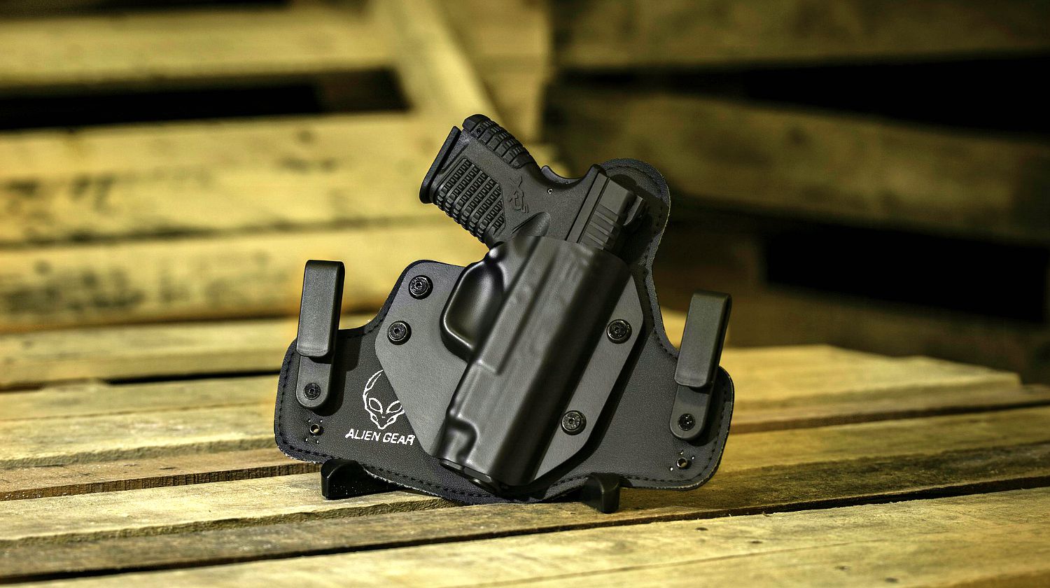 Feature | Automatic handgun with black holster on a wooden background | What's The Best Handgun For Beginners?