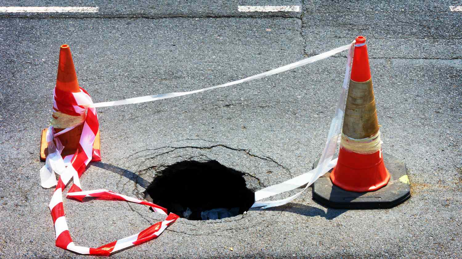 Feature | Road hole with warning cones and tape | Sinkholes Survival Life Tips | How To Prepare For The Worst