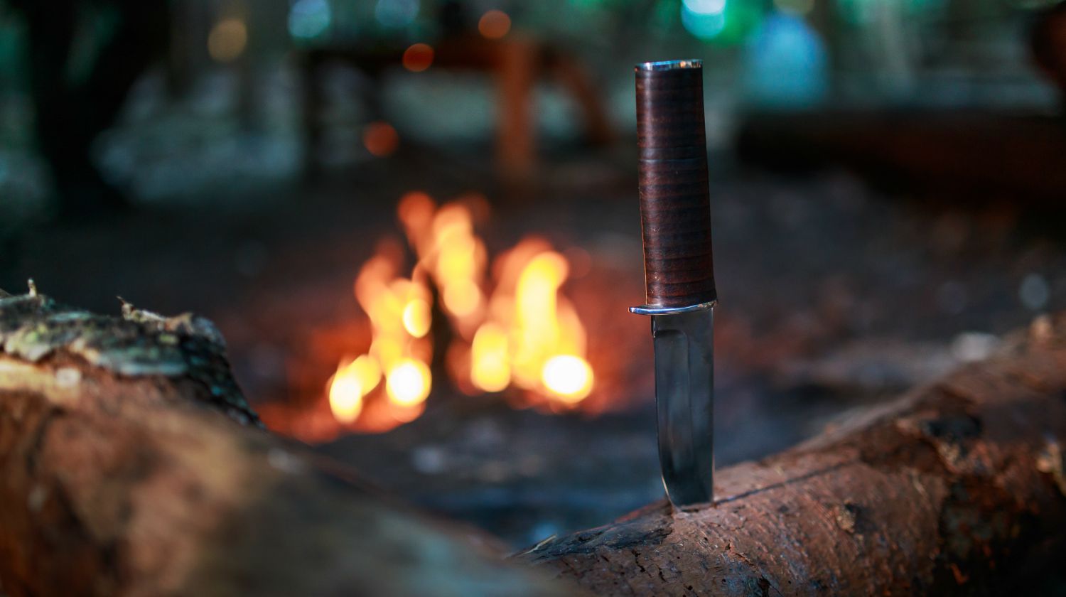 Knife in wood by fire | Best Survival Knife Brands You Can Trust | Featured