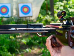 Woman aiming crossbow at target outdoor | How To Use A Crossbow And Why Use It Over Guns | Featured