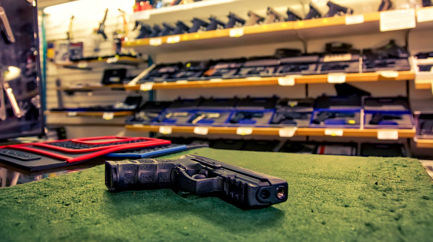 Featured | Black combat pistol gun shop store dealing countertop weapons dangerous sales felt surface display | Bersa Thunder .380 Combat