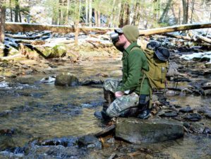 Man along a mountain stream in the forest | Outdoor Survival Skills For The True Outdoorsman | Featured