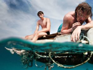 Featured | Two men floating in a sea with sad faces | Lost At Sea Survival Guide | Tips And Tricks For Ocean Navigation