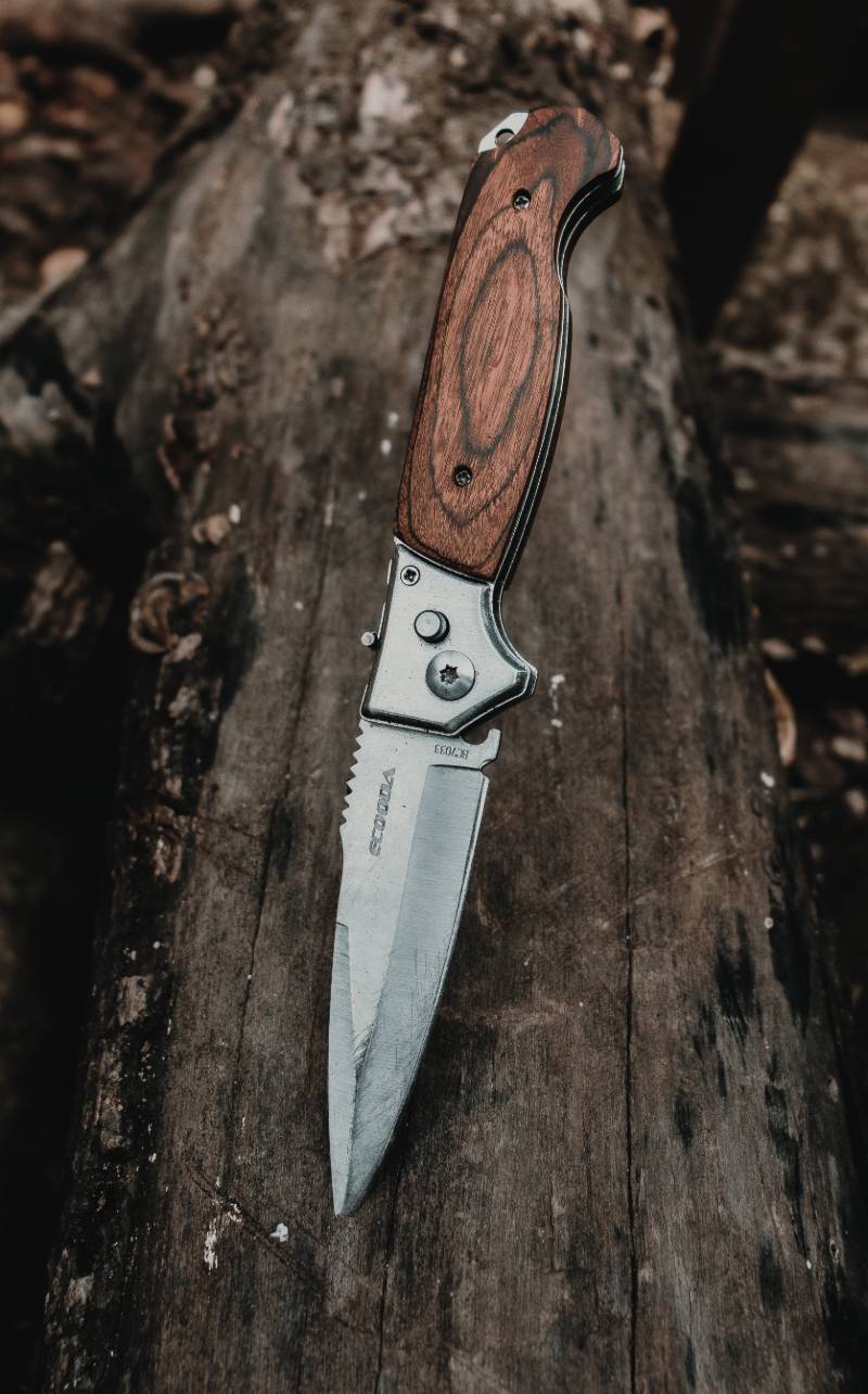 brown handle silver knife on brown wooden surface | Rhode Island Knife Laws