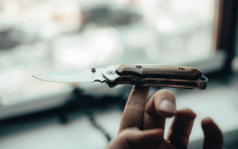 person holding silver and brown pocket knife | South Dakota Knife Laws