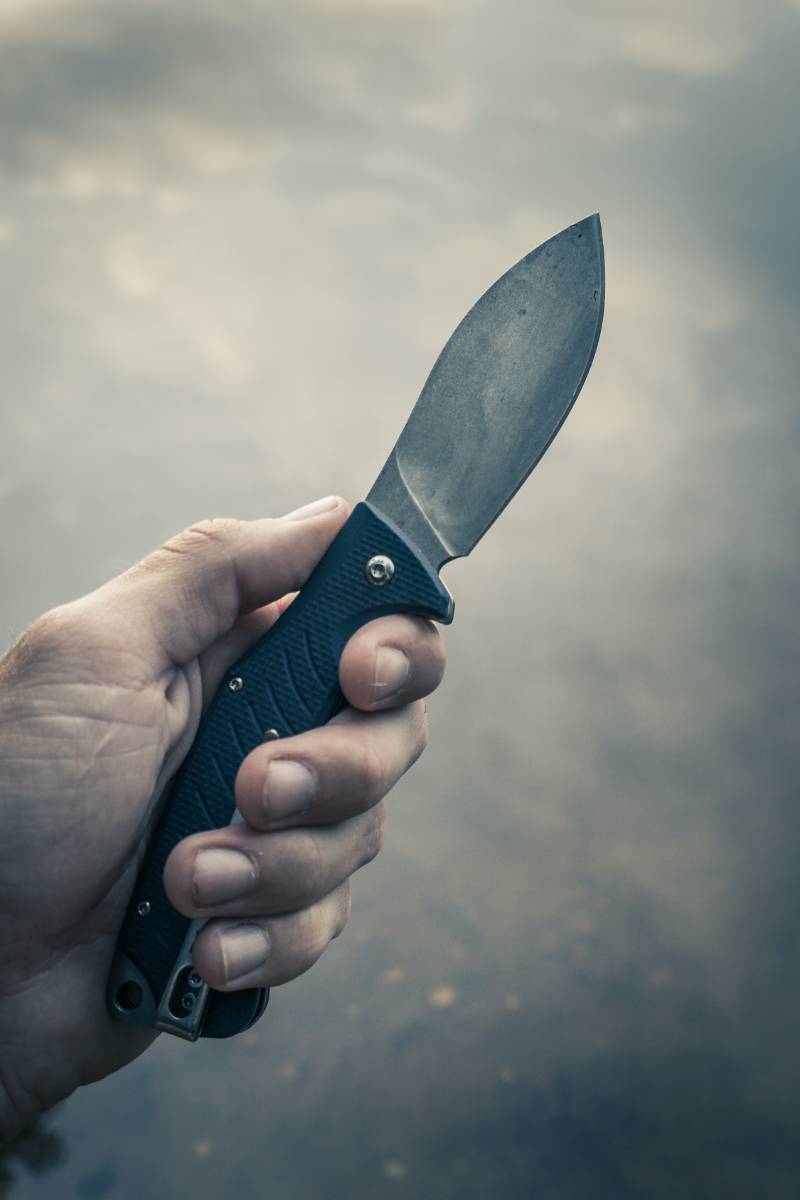 person holding black handle knife | Arizona Knife Laws