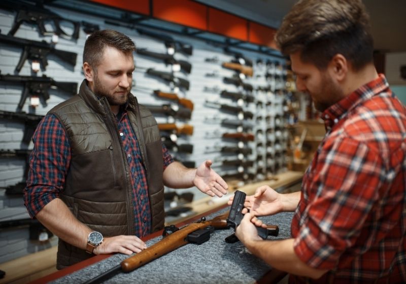 Man with owner choosing handgun | Best caliber for self defense