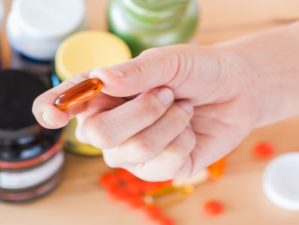 Feature | Close up of hand is holding a medicine bottles background | OTC Meds For Survival Kit