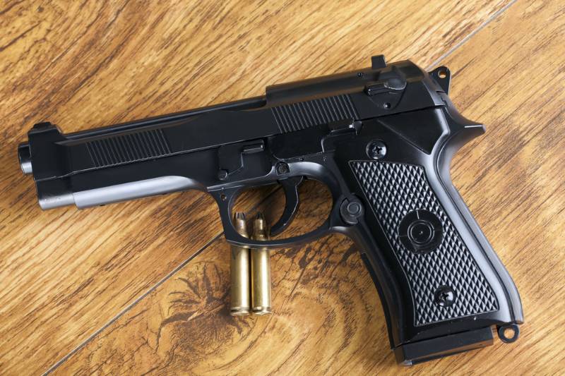 Handgun and brass bullets on wooden background best full size 9mm