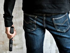 killer-holding-gun-side-him-robbery | Beretta 21A Bobcat | Gun Carrier Handgun Review | Featured