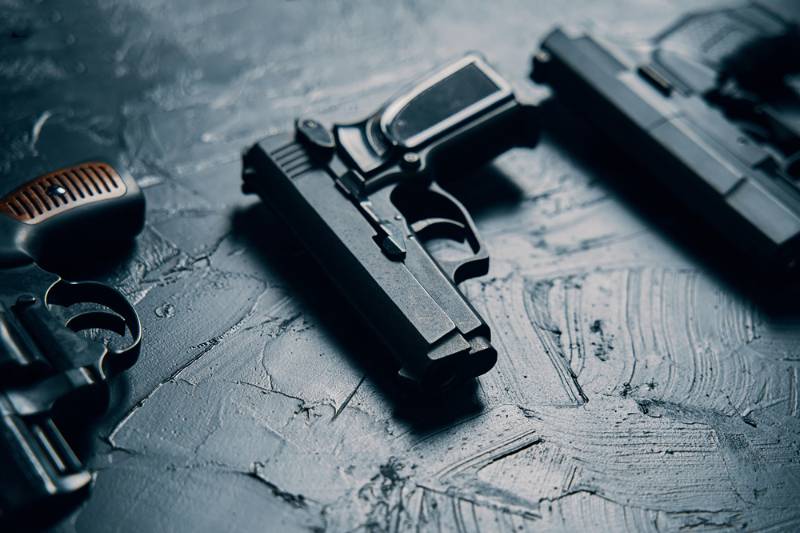 group pistols on black concrete table | must have pistols Gun Firing Must Have Pistols | 36 Best Must Own Handguns For Beginners Or Defense