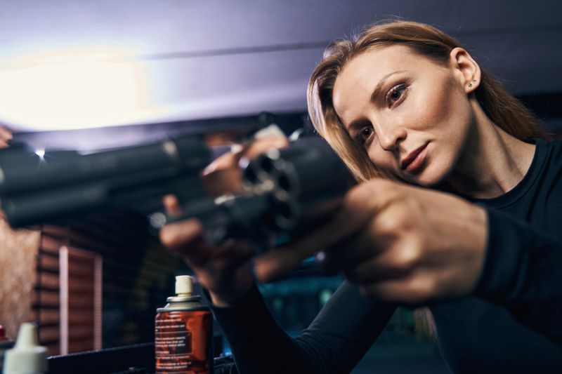 concentrated-woman-sniper-examining-unloaded-sixshooter woman concealed carry