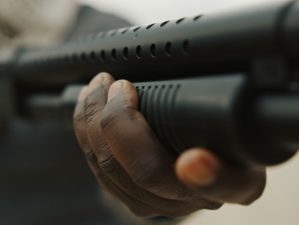 afroamerican-man-reloads-pump-action-shotgun home defense pump shotgun | Featured Image