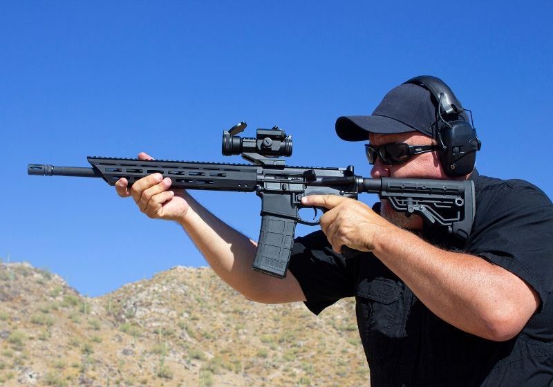 Man firing ar 15 style rifle at range What does ar stand for SS