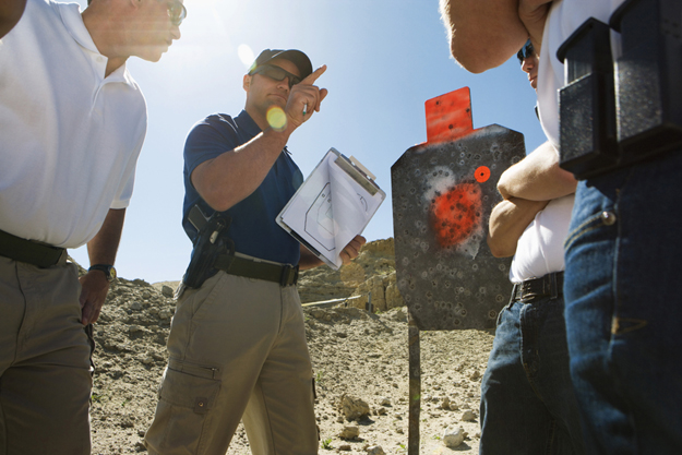 Instructor holding clipboard in front of group on shooting range | Interesting and Fun Facts About Bullets