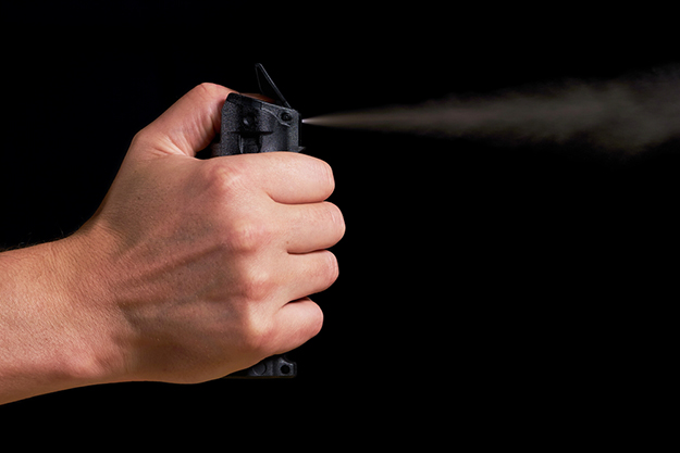 man aiming spraying pepper spray visible non lethal weapon
