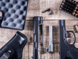 still life disassembled handgun bullet on gun maintenance guide