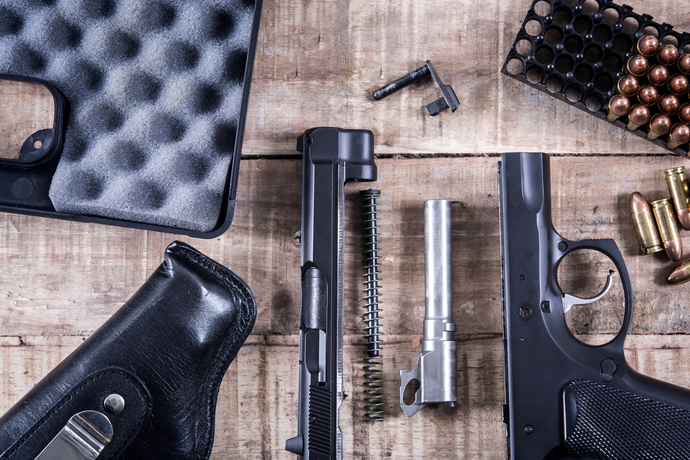 still life disassembled handgun bullet on gun maintenance guide