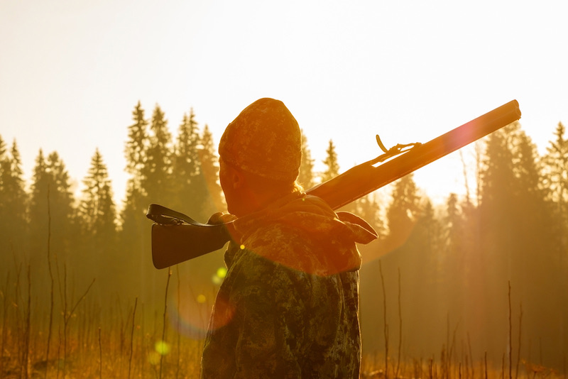 Silhouetted of a hunter with shotgun at beautiful sunset | pheasant hunting season wisconsin 2020