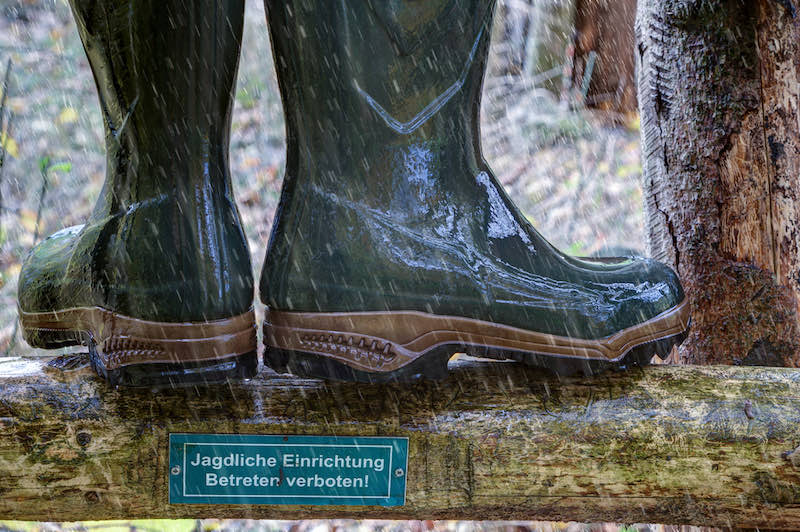 Wellington boots stand in the rain on the wooden ladder of a hunting pulpit | pheasant hunting season