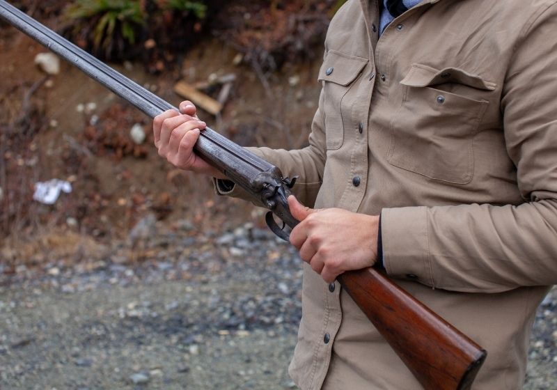 A man holds an old antique double barrel shotgun Pistol grip shotgun SS