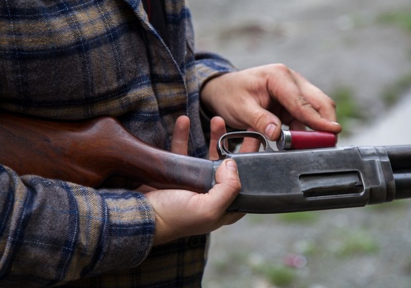 Man loading a red shotgun shell into the magazine Pistol grip shotgun SS