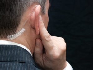 Close-up of a secret service agent listening to his earpiece, over the shoulder-Hunter Biden-ss-featured