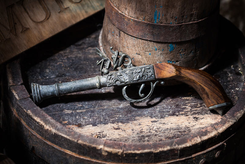 Model of the old vintage gun on wooden background | powder rifles