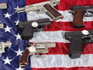 Pistols and revolver assorted firearms for sale on USA America flag at gun show-US Gun Sales-ss-featured