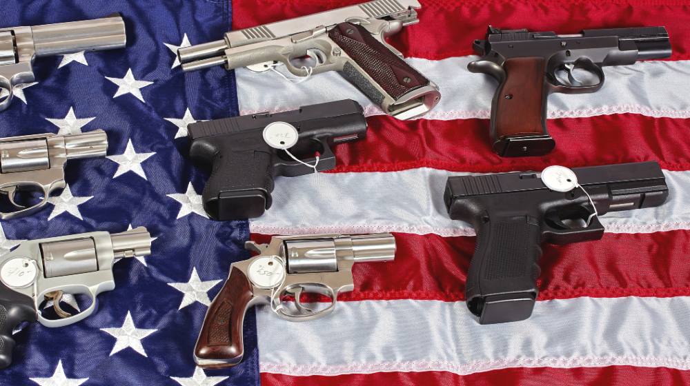 Pistols and revolver assorted firearms for sale on USA America flag at gun show-US Gun Sales-ss-featured