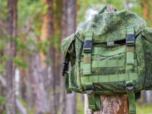 small backpack hanging on trunk tree | How To Turn Your Bug Out Bag Into A Minimalist Backpack | featured
