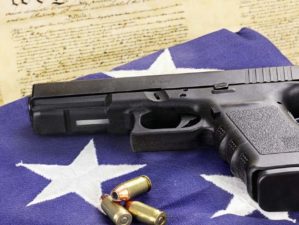 A 45 caliber handgun and ammunition resting on a folded flag against the United States constitution | 5 Awesome .45 ACP Handguns You Must Have | Featured