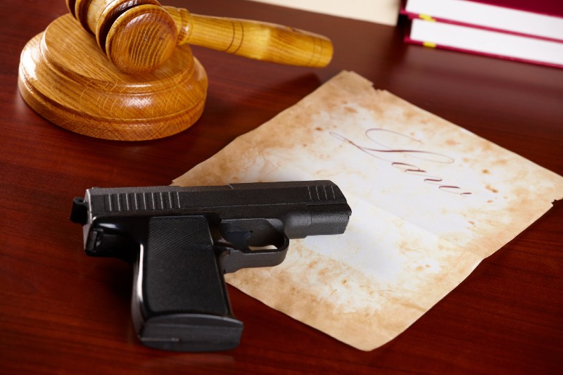 Judges wooden gavel with gun and very old paper with word law | airgun