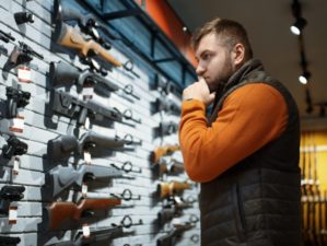 Man looking on handguns, showcase in gun shop-Essential Guns-ss-featured