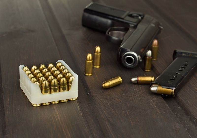 Handgun with ammunition on a dark wooden table 17hmr vs 22mag SS
