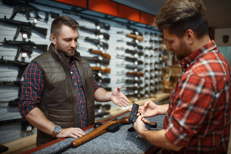 Man with owner choosing handgun in gun shop | ruger mark iv for sale