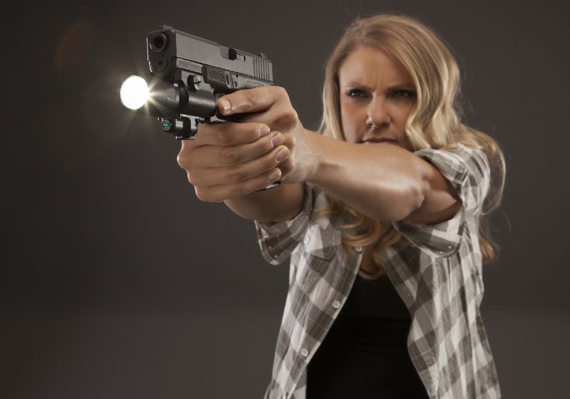 Serious woman with a flashlight and a pistol Sig Sauer P365 vs Glock 43 SS