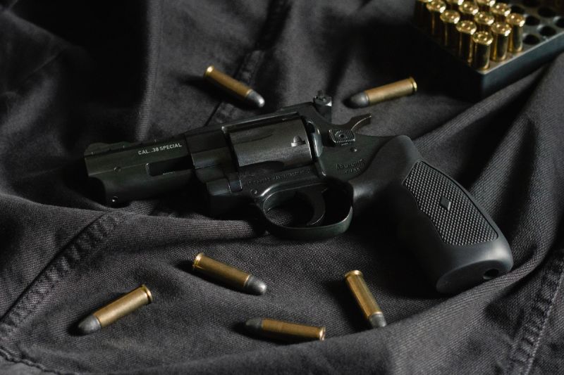 A black revolver on black cloth, with ammunition | modern revolvers