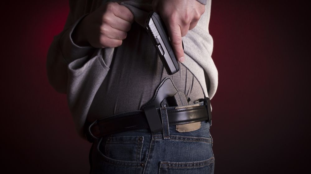 7 Best Concealed Carry Holsters Perfect For Your Gun | A man drawing a conceal carry pistol Best concealed carry holsters | Featured