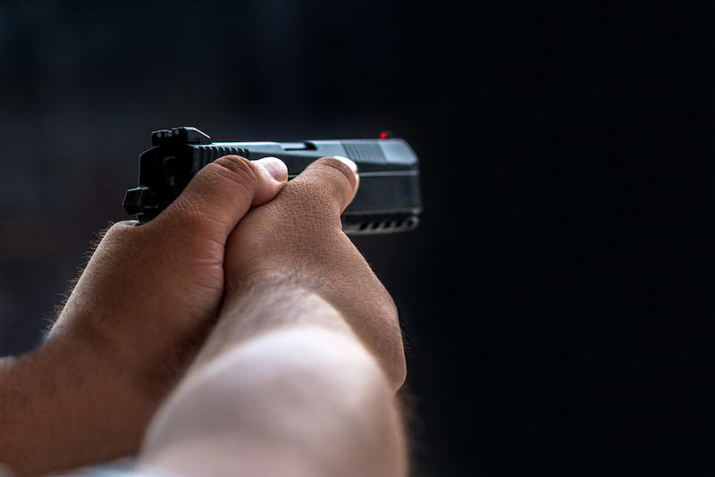 Man aiming pistol in shooting range | bersa thunder 380 plus
