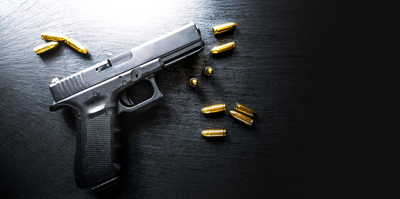 Top view of hand gun on black background | best 9mm handgun for beginners